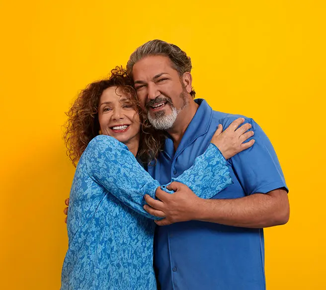 Casal feliz usando aparelhos auditivos